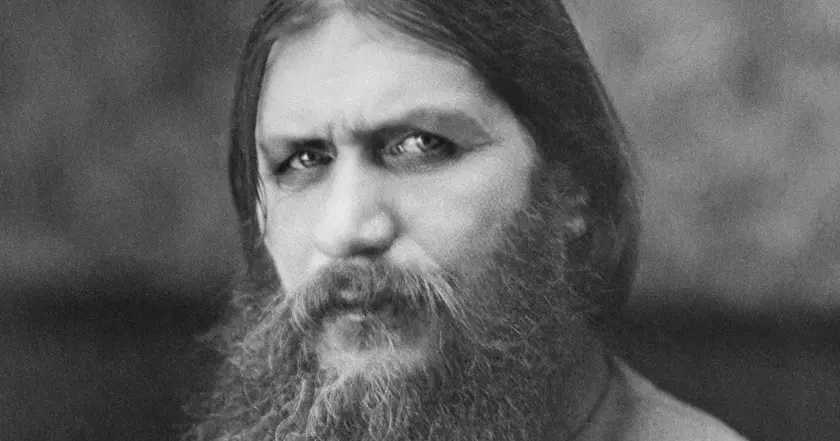 Portrait en noir et blanc d'un homme à la barbe fournie et aux cheveux longs, regard intense.